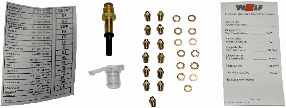 WOLF Umrüstsatz mit verschiedenen Messingfittings, Dichtungen und einem transparenten Filter. Zubehörteile für Gasinstallationen in übersichtlicher Anordnung.
